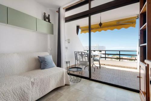 een woonkamer met een bank en uitzicht op de oceaan bij Apartment La Luna in Puerto de Santiago