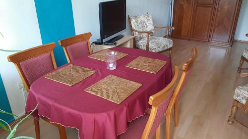 uma mesa roxa com cadeiras e uma televisão num quarto em Oase der Ruhe und Entspannung em Bad Homburg vor der Höhe