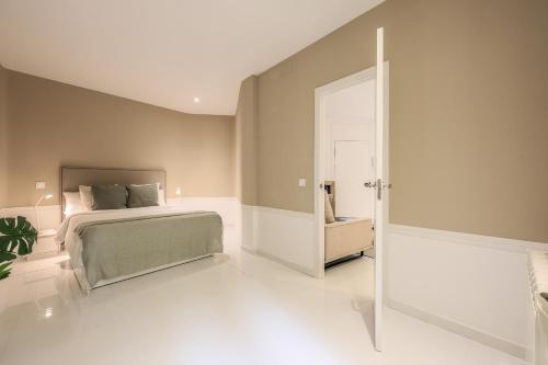 Schlafzimmer mit einem Bett und einer Glasschiebetür in der Unterkunft AP Embajadores XV in Madrid