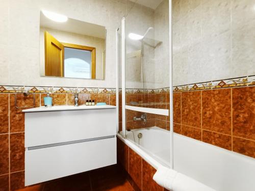 y baño con bañera, lavabo y espejo. en Parque Marino 5206 - Resort Choice, en Cabo de Palos