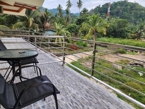 a patio with a table and chairs on a balcony at Juara Mutiara Resort in Tioman Island