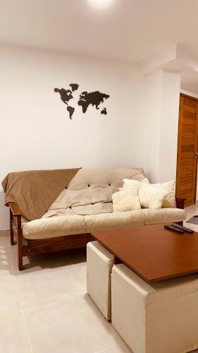 1 dormitorio con 1 cama con mesa y mapa en la pared en Tierra en Ushuaia