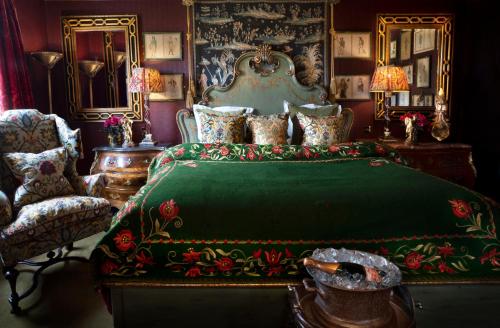 a bedroom with a green bed with a green blanket at Prestonfield House in Edinburgh