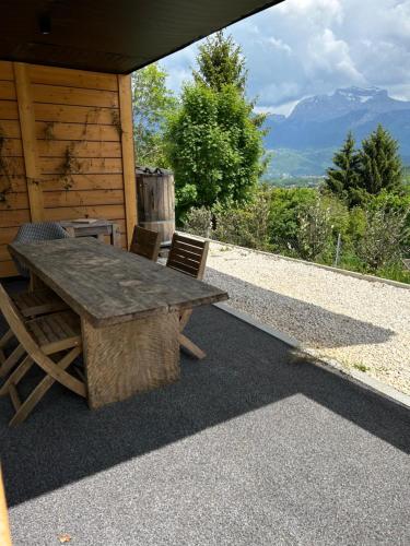a wooden table and chairs sitting outside of a cabin at Le Cabanon in Saint-Jorioz