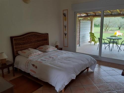 - une chambre avec un lit et une terrasse avec une table dans l'établissement Petit Mazet PROVENCE, à Eyragues