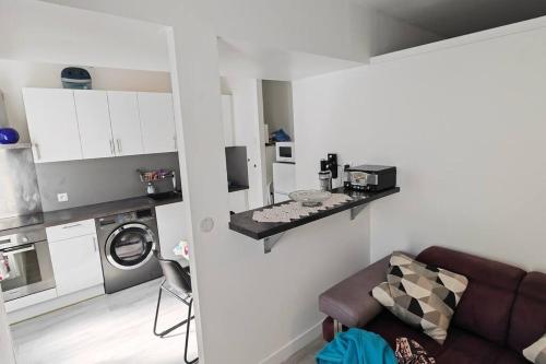 a living room with a couch and a microwave at Appartement cosy 2 pièces hyper centre in Rochefort