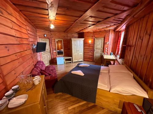 1 dormitorio con 1 cama en una cabaña de madera en Penzion Ten, en Pardubice