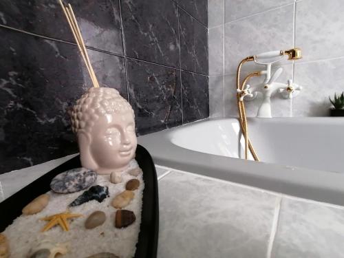 a statue of a head in a bath tub in a bathroom at La Musa - Appartamento Clio in Spello