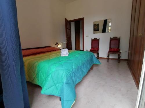a bedroom with a colorful bed and two chairs at La Musa - Appartamento Clio in Spello