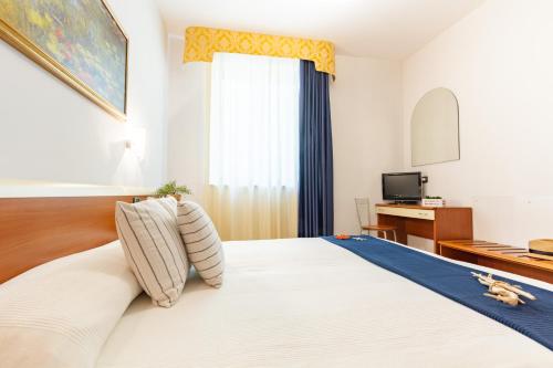 um quarto com uma grande cama branca e uma janela em Appartamento Alide Bilo Deluxe - MyHo Casa em Tortoreto Lido