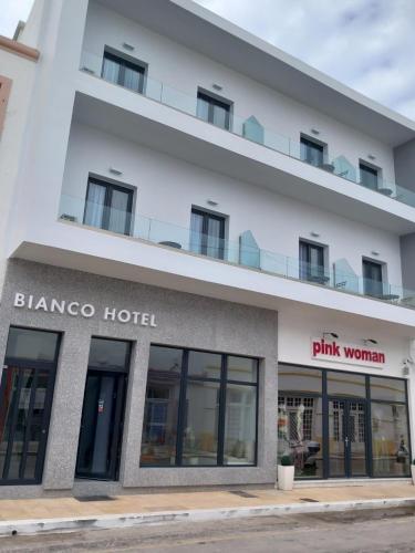 a large white building with a pink woman hotel at Bianco Hotel in Lakkíon