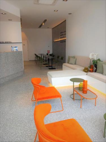 a living room with orange chairs and a couch at Bianco Hotel in Lakkíon