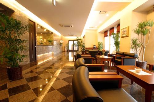 a lobby with couches and tables in a restaurant at Hotel Route-Inn Mojiko in Kitakyushu