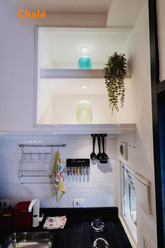 a kitchen with a sink and a shelf with utensils at Minicasa Brasileira in Sorocaba
