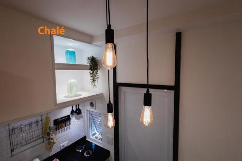 a kitchen with three lights hanging from the ceiling at Minicasa Brasileira in Sorocaba