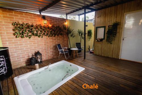 a large bath tub in a room with a brick wall at Minicasa Brasileira in Sorocaba