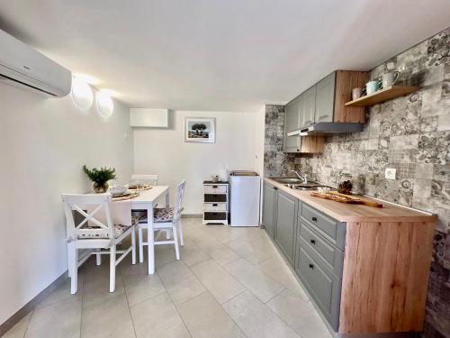 a kitchen with a table and chairs and a counter at Apartment Amalia Volosko in Opatija