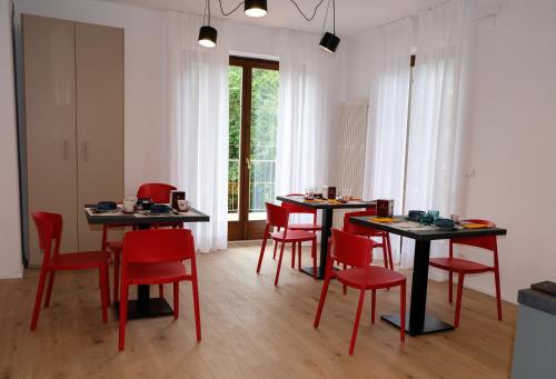 a dining room with two tables and red chairs at Countryhouse Verso in Rovereto