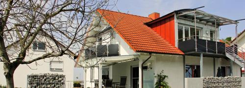 ein orangefarbenes Dach auf einem Haus mit einem Baum in der Unterkunft Ferienwohnung Savoir Vivre in Kiechlinsbergen