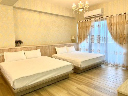 a bedroom with two beds and a window at 花蓮漫漫時光電梯包棟民宿 in Hualien City