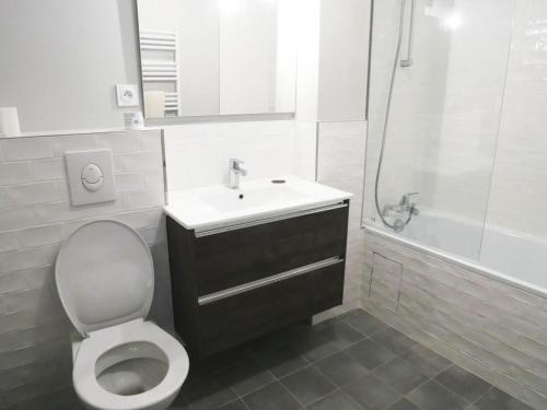 a bathroom with a toilet and a sink and a shower at Les Coteaux in Montgeron