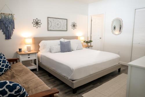 a bedroom with a white bed and a couch at Clearwater Bohemian Escape - 7 min to the Beach, BBQ Grill, Playground in Clearwater