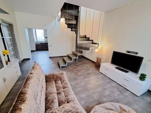 a living room with a couch and a flat screen tv at Naykova district Apartments in Kharkiv