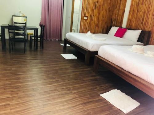 a room with two beds and a table and a desk at กอบสุข รีสอร์ท2 k04 in Ban Ton Liang