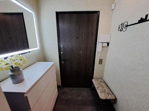 a bathroom with a brown door and a white counter and a cabinet at Naykova district Apartments in Kharkiv