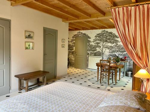 une chambre avec un lit, un bureau et une table dans l'établissement Chambres d'Hôtes Les Bournais - Le Clos Milady, à L'Ile-Bouchard