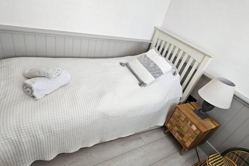 a bedroom with a white bed with a night stand and a lamp at Humberston Boathouse Lodge & Hot Tub - Cleethorpes Beach Cabin Chalet in Humberston