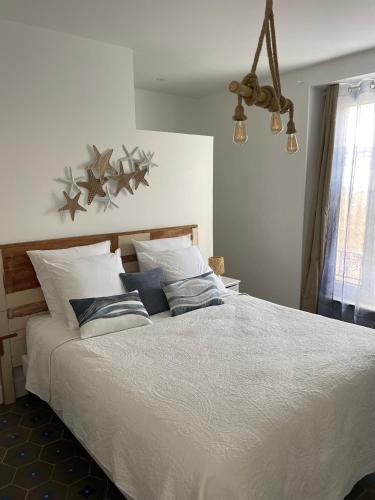 une chambre avec un grand lit blanc avec des oreillers dans l'établissement La Maison du Puits B&B Minervois, à Cesseras