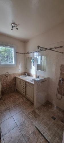 La salle de bains est pourvue d'un lavabo, d'une baignoire et d'une fenêtre. dans l'établissement Villa de 240 m2 au calme avec piscine, à Salon-de-Provence