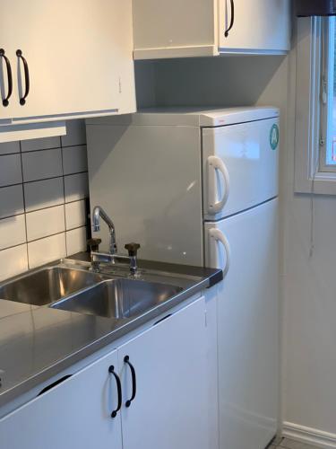 a kitchen with a sink and a refrigerator at Stuga i vassemåla in Vimmerby