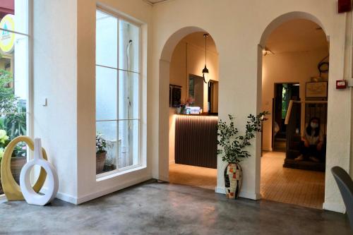 a hallway with arched windows and a room with a table at Shenzhen Loft Youth Hostel in Shenzhen