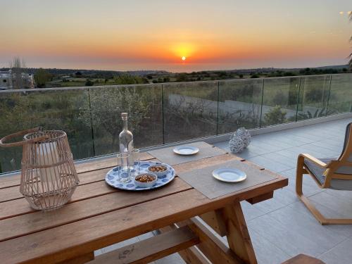 una mesa de madera con un plato de comida en el balcón en Villa Phos, en Káthikas