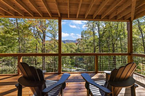 a screened porch with chairs and a view of the mountains at Angels Share in Seven Devils