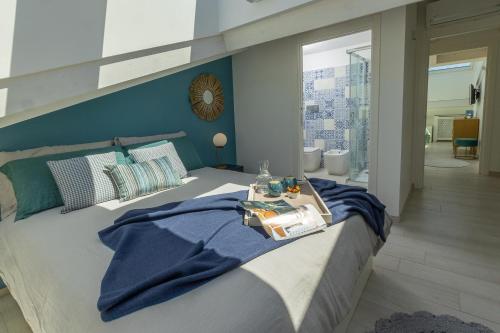 a bedroom with a bed with a blue wall at Melifra, Jacuzzi e Vista Panoramica in Ispica