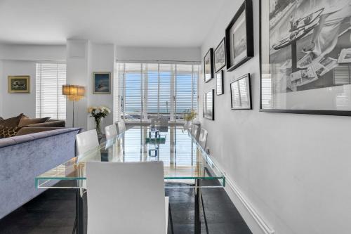 een woonkamer met een glazen tafel en een bank bij Deco Seafront - By My Getaways in Brighton & Hove