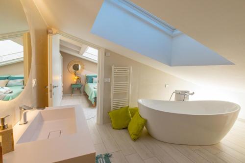 a bathroom with a large white tub and a bedroom at Melifra, Jacuzzi e Vista Panoramica in Ispica