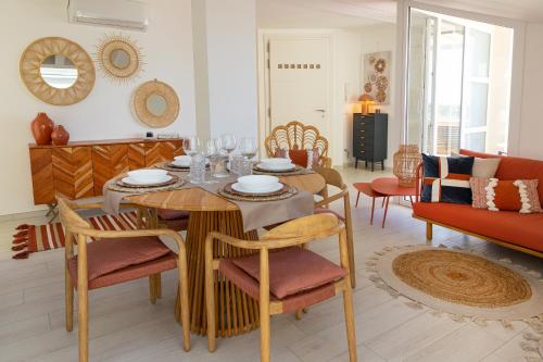 a dining room with a table and chairs in a living room at Melifra, Jacuzzi e Vista Panoramica in Ispica