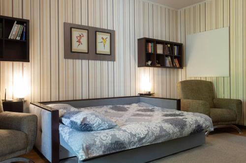a bedroom with a bed and two chairs in a room at Naykova district Apartments in Kharkiv