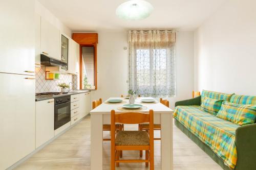 Il comprend une cuisine et un salon avec une table et un canapé. dans l'établissement Appartamento Alide Bilo 1P - MyHo Casa, à Tortoreto Lido