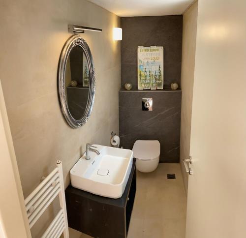 een badkamer met een wastafel, een toilet en een spiegel bij Nefeli Villas in Chersonissos