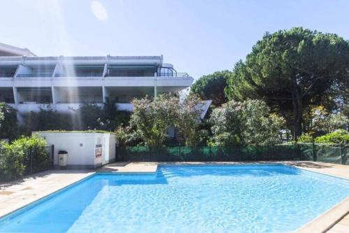 una gran piscina frente a un edificio en Appartement familial, terrasse, piscine et parking en La Grande-Motte