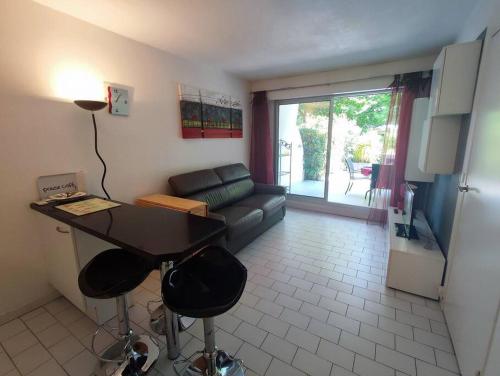 sala de estar con mesa y sofá en Appartement familial, terrasse, piscine et parking en La Grande-Motte