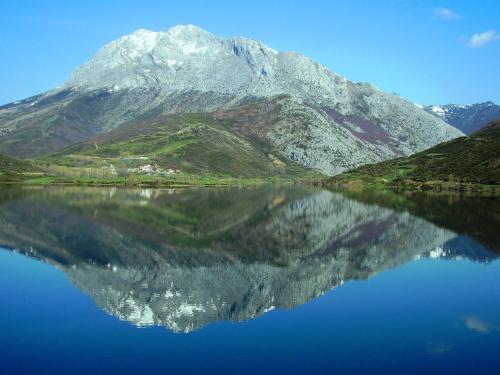 una montaña reflejada en un cuerpo de agua en Albergue el Caseron de Fuentes Carrionas, en Cardaño de Abajo