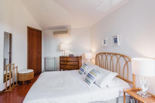 um quarto com uma cama branca com lençóis e almofadas brancos em Casa Magnolia by Wonderful Italy em Aci Castello
