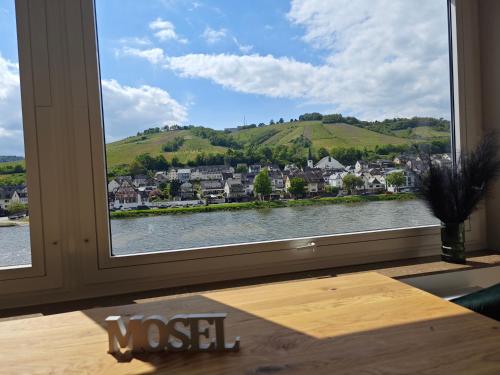 a window with a view of a town and water at Ferienwohnung Schöne Aussicht in Zell an der Mosel