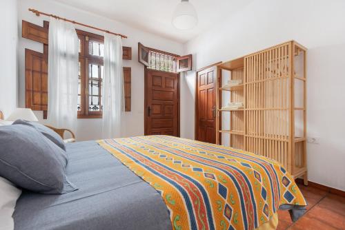 a bedroom with a bed with a colorful blanket on it at Casa Hilaria in Garachico